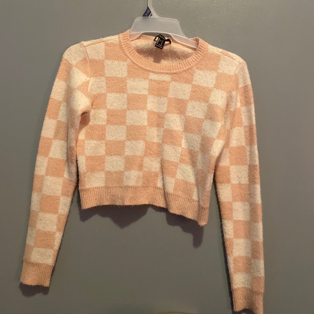 Pink and white checkerboard sweater. Worn. Size Small.